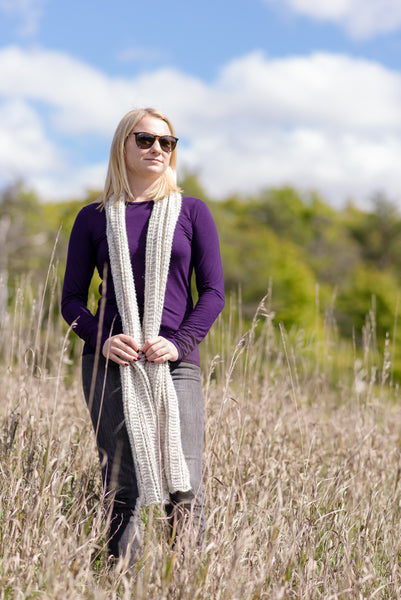 young woman wearing handknit scarf in field